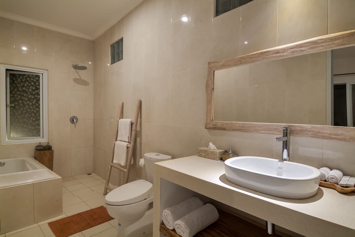 A modern bathroom with a bathtub, toilet, and sink.