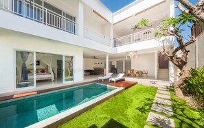 Une maison moderne à deux étages, dotée d’une piscine, d’un coin repas et d’un balcon.