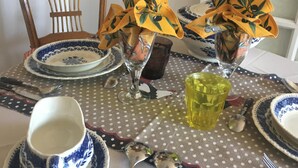 A dining table set with blue and white patterned plates, silverware, and a yellow glass. - Perfect place to escape from routine in the heights of Nice (Nice)