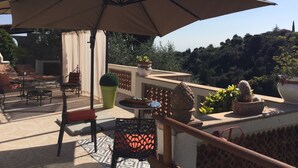 An outdoor patio with a large umbrella, seating, and potted plants. - Perfect place to escape from routine in the heights of Nice (Nice)