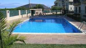 A rectangular swimming pool with a tiled deck, surrounded by a fence and greenery. - Barreiros Apartment - Catedrales Beach 5 pers. (2 rooms) views to the Foz Estuary (Barreiros)