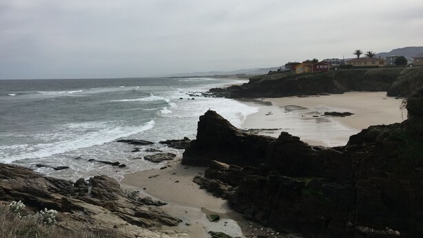 A coastal landscape with rocky cliffs, a sandy beach, and a row of houses along the shore. - Barreiros Apartment - Catedrales Beach 5 pers. (2 rooms) views to the Foz Estuary (Barreiros)