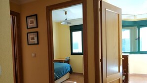 A bedroom with a bed, a window, and a door leading to another room. - Barreiros Apartment - Catedrales Beach 5 pers. (2 rooms) views to the Foz Estuary (Barreiros)
