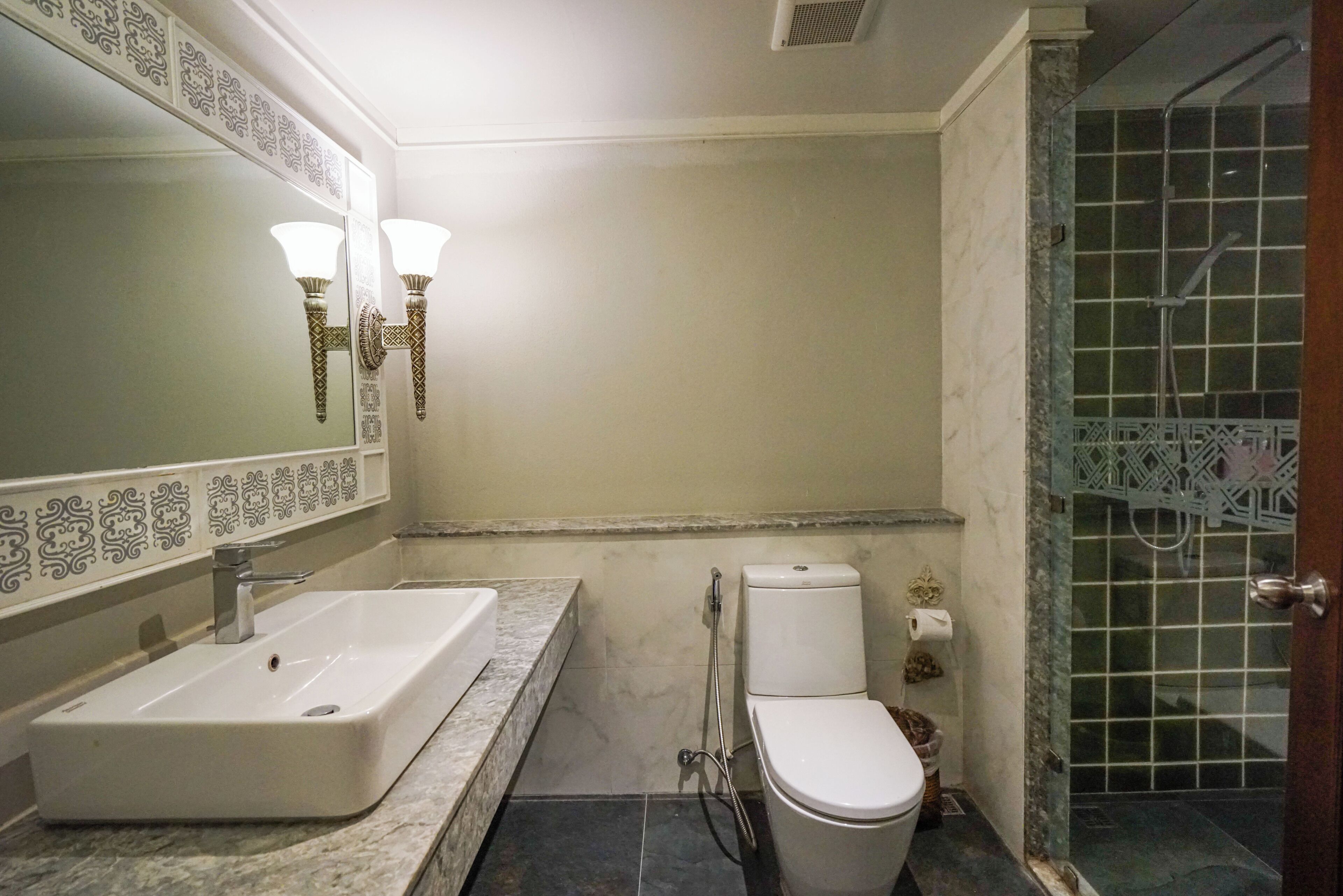 Un baño con lavamanos, inodoro y ducha.
