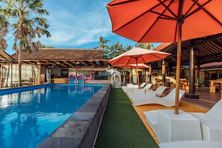 Una piscina al aire libre, sillones reclinables de piscina