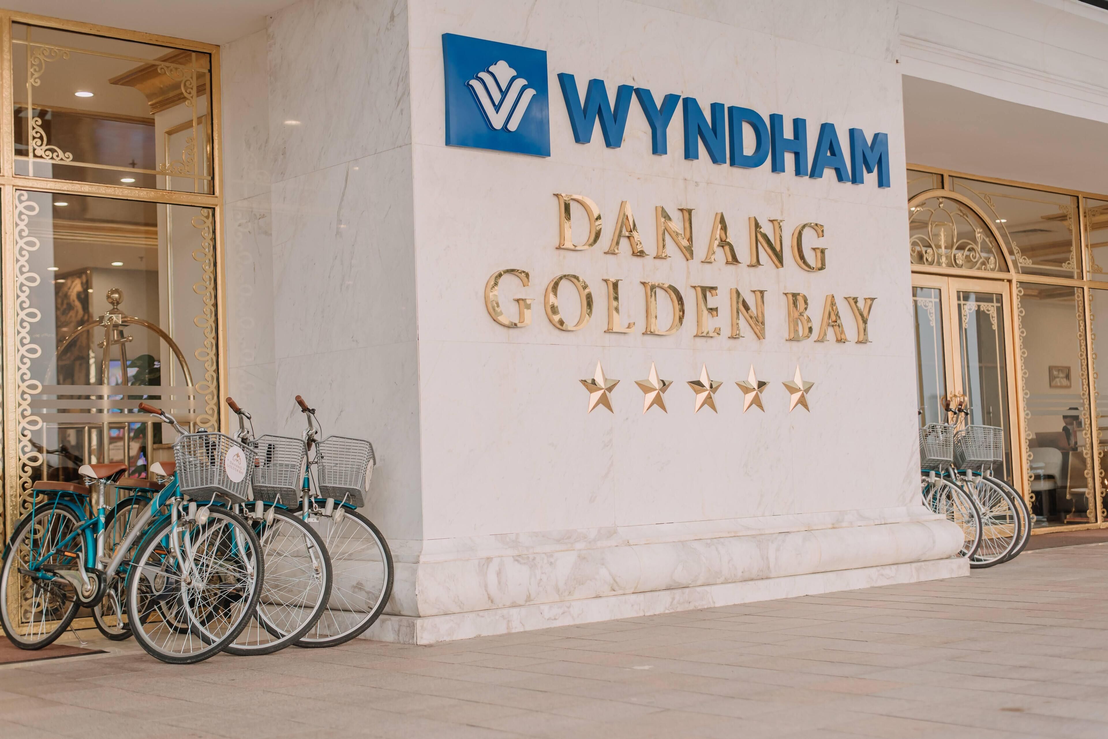 Placa do Wyndham Danang Golden Bay com fachada de mármore e letras douradas.
