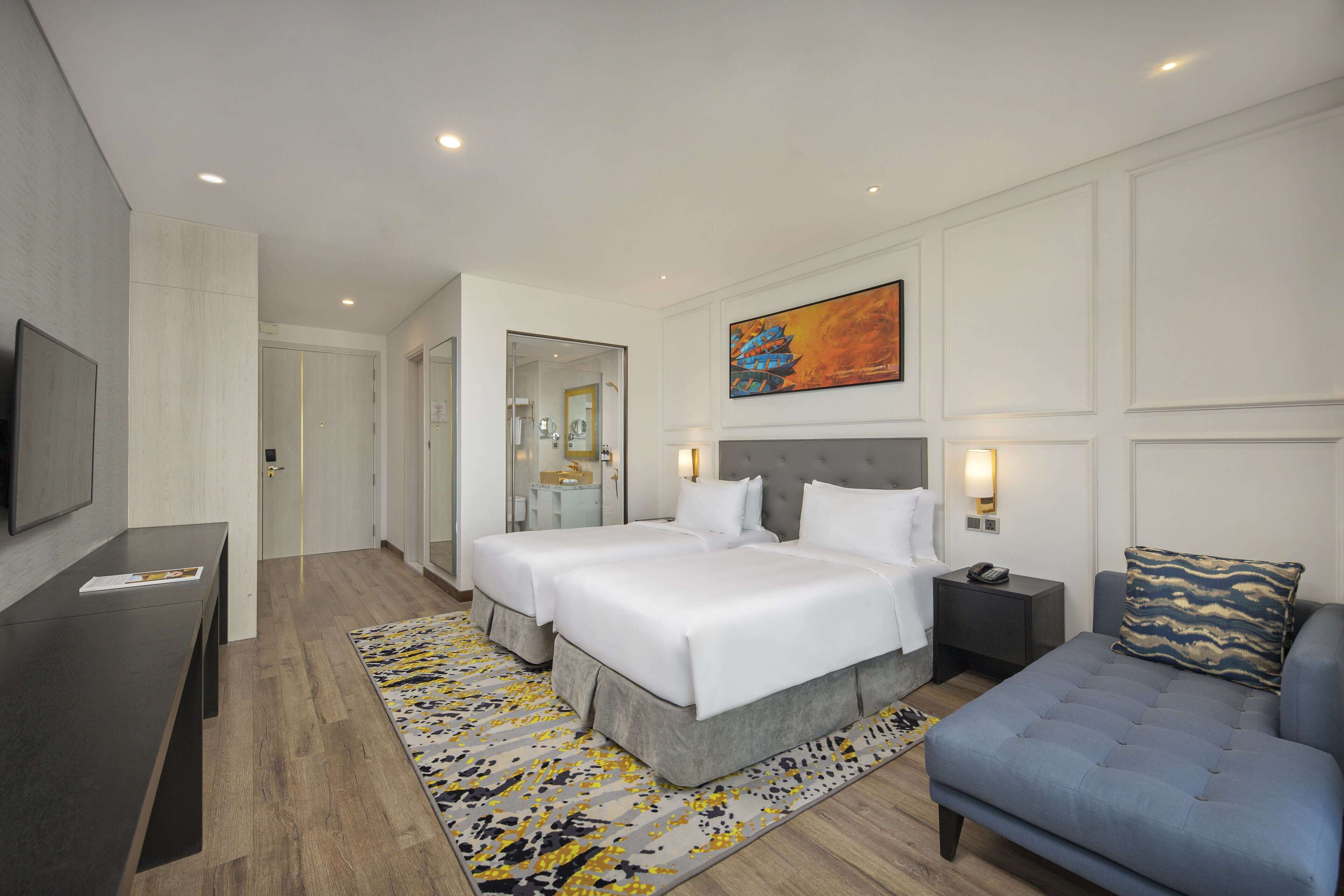 Ein modernes Hotelzimmer mit einem großen Bett, einem Schreibtisch und einer Sitzecke.