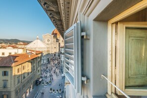Vista desde un balcón sobre una plaza animada con edificios históricos, incluyendo una cúpula destacada.