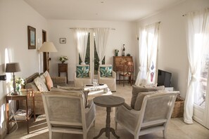 A living room with wicker furniture, a coffee table, and a television.