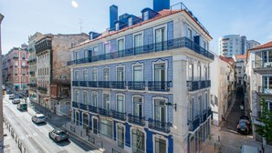 Un immeuble à plusieurs étages doté de balcons, une rue en contrebas et un ciel dégagé.