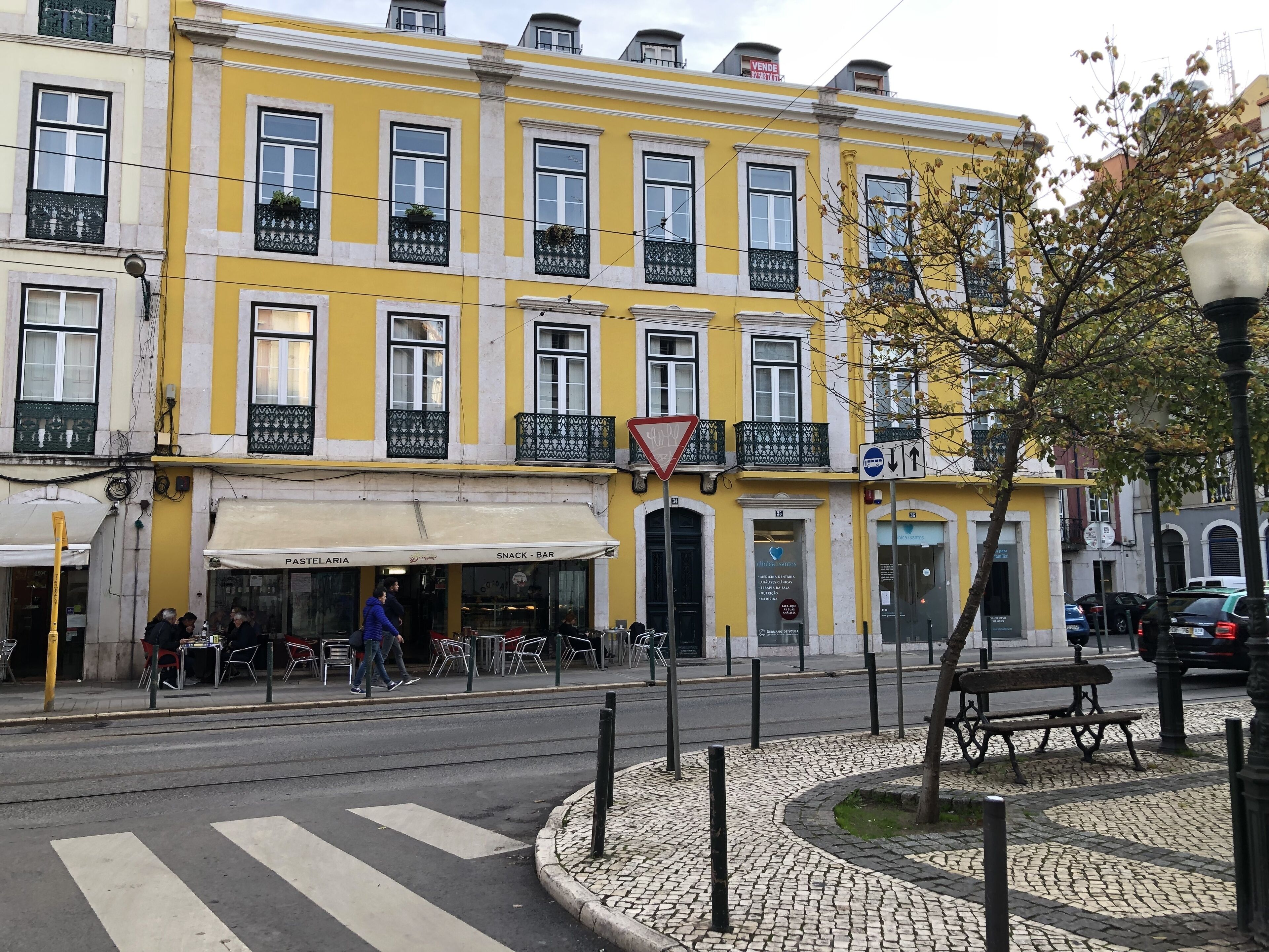 A yellow building with a café named 'PASTELARIA' and a 'SNACK BAR' on the ground floor.