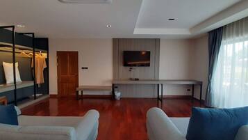 Una sala de estar moderna con un televisor de pantalla plana, un banco y un perchero.