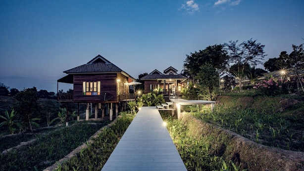 A wooden house with a porch and a pathway leading to it.