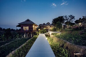 A wooden house with a porch and a pathway leading to it. - Buraphat Resort (Chiang Dao)