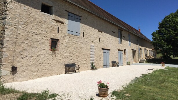 A stone building with multiple windows and doors, a gravel driveway, and a bench. - Farmhouse for 15 people, swimming pool, SPA, billiards, air conditioning (Luzy)