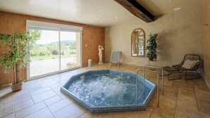 A spacious indoor area with a hot tub, large windows, and a view of the outdoors. - Farmhouse for 15 people, swimming pool, SPA, billiards, air conditioning (Luzy)
