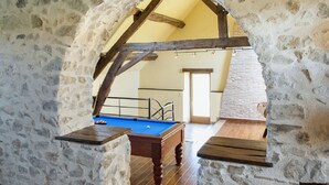 A stone-walled room with a wooden floor, a pool table, and a staircase leading to an upper level. - Farmhouse for 15 people, swimming pool, SPA, billiards, air conditioning (Luzy)