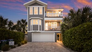 A two-story house with a garage, a balcony, and a well-lit entrance.
