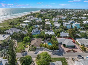 Zona residencial costera con casas, una playa y una piscina.