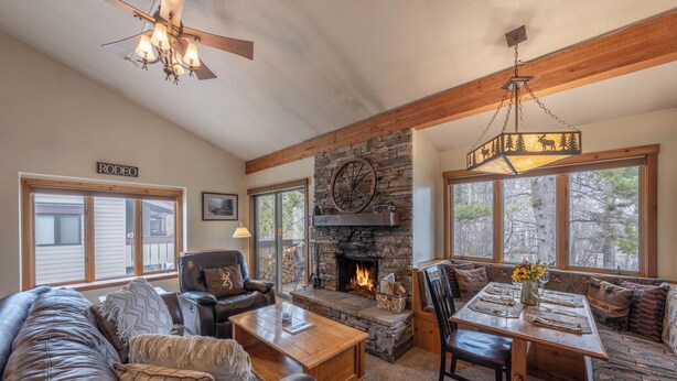 A cozy living room with a stone fireplace, leather furniture, and large windows. - Fresh interior, excellent location in Aspens (Wilson)