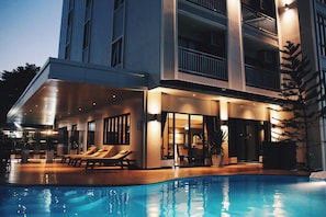 A modern hotel with a swimming pool, outdoor lounge area, and multiple balconies. - Golden Foyer Suvarnabhumi Airport Hotel (Bangkok)