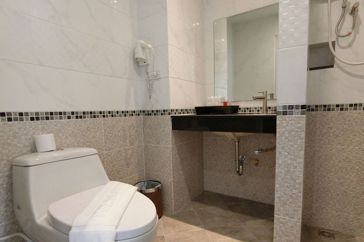 Un bagno con il water, un lavandino, uno specchio e una doccia.