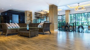 Ein geräumiger Wohnbereich mit einer hölzernen Bank, einem Couchtisch und einem Bücherregal.
