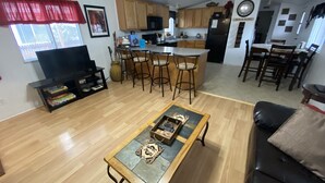A modern living room with a coffee table, TV, and bookshelves. - 50% to Book Home - Super Clean 3BR- Sleeps 6- By TNT (Page)