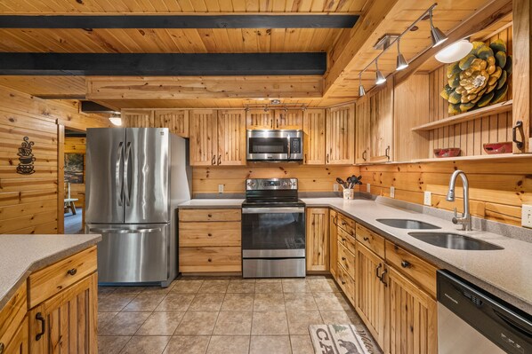 Fully equipped kitchen with central island, stainless steel appliances, and two sinks.
