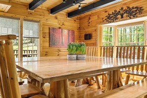 Enjoy meals around the large dining table surrounded by comfortable chairs, with a view of the surrounding forest through the large window.