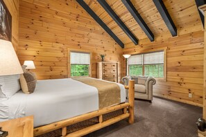 Cozy bedroom with a large bed, sloped ceiling, and a reading nook.