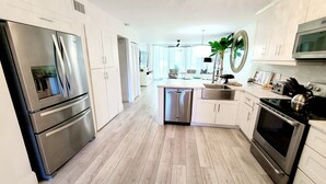 A modern kitchen with stainless steel appliances, a dishwasher, and a microwave. - POSHPADZ-Bella Lago-Ground Floor, Walk to Jupiter Beach, Patio with Lake Views (Jupiter)