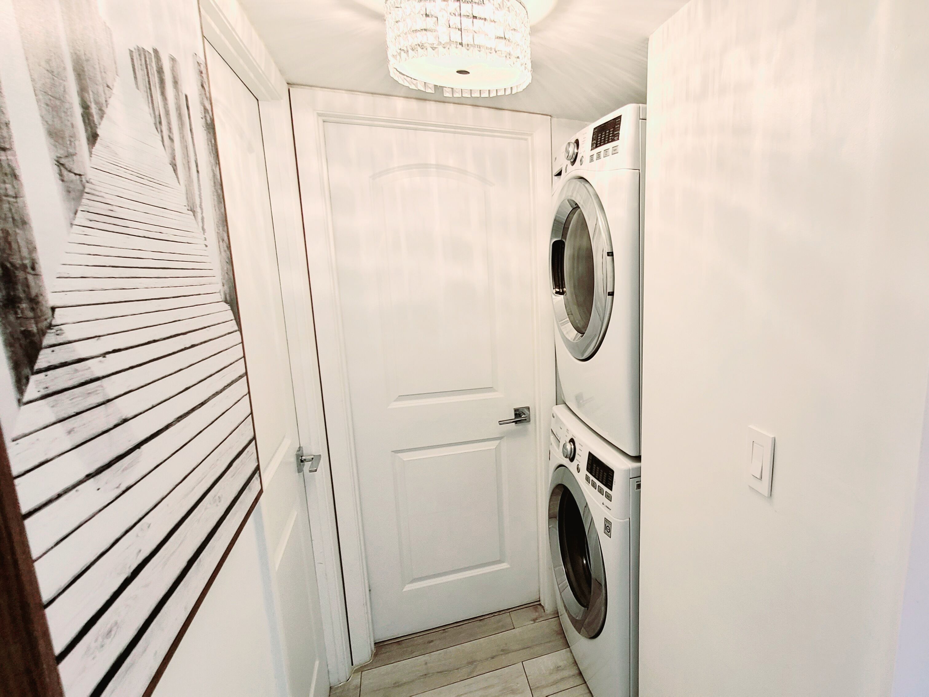 A laundry room with a door, a washing machine, and a dryer.