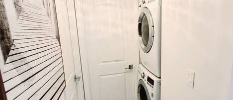 A laundry room with a door, a washing machine, and a dryer.