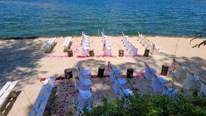 A beach ceremony setup with white chairs and tables, arranged on the sand with rose petals. - Aubreys Lakewood Cabin -FREE DAY w Qualified Booking- Fishing, Football Friendly (Eclectic)