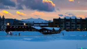 Paisaje nevado con un edificio al fondo y un puente en primer plano.