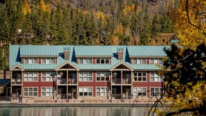 Un hotel de varios pisos con un patio central, balcones y vistas a un lago.