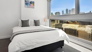 Una habitación de hotel moderna con una cama grande, vistas a la ciudad y una decoración minimalista.