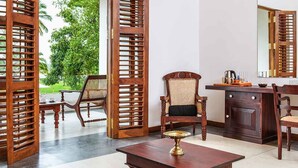 A room with a wooden table, two chairs, a cabinet, and a large mirror. - The Notary's House (Pannala)
