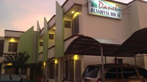 A multi-story building with a sign reading "Danel Pension House." There are multiple windows on the facade, and a car is parked in front. - Danel Pensionne House (Tacloban)