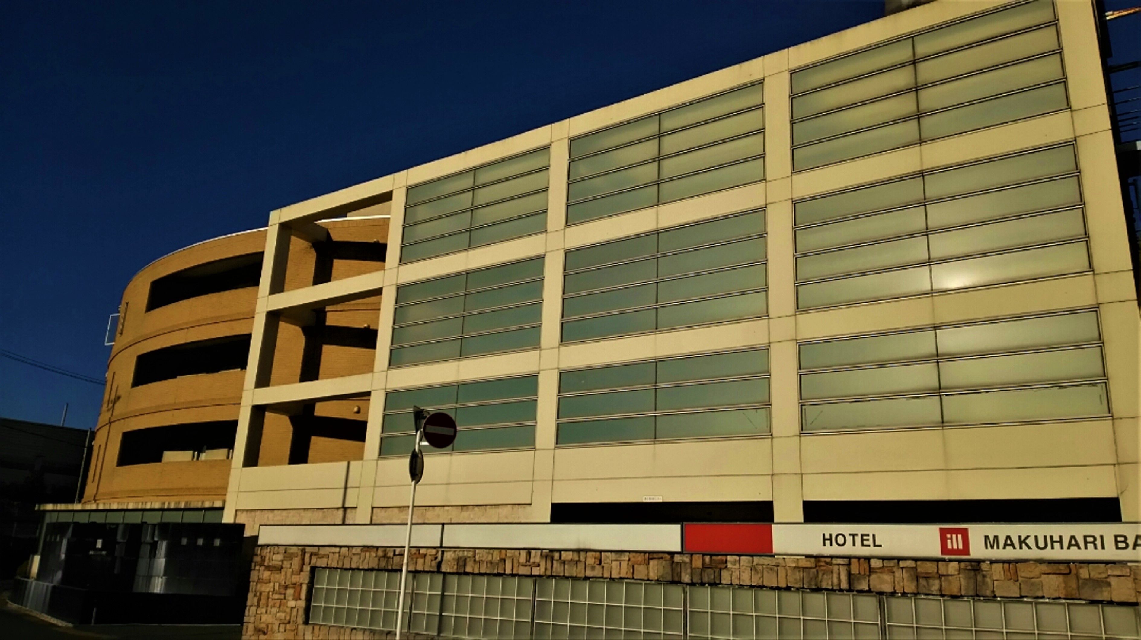 A hotel building with a modern architectural design, featuring multiple floors and large windows.