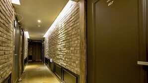 A hallway with brick walls and a polished floor, leading to a door marked "407". - Ulsan Hotel 109 (Ulsan)