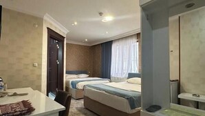 Habitación de hotel con dos camas, un escritorio, una silla, un armario y un baño.