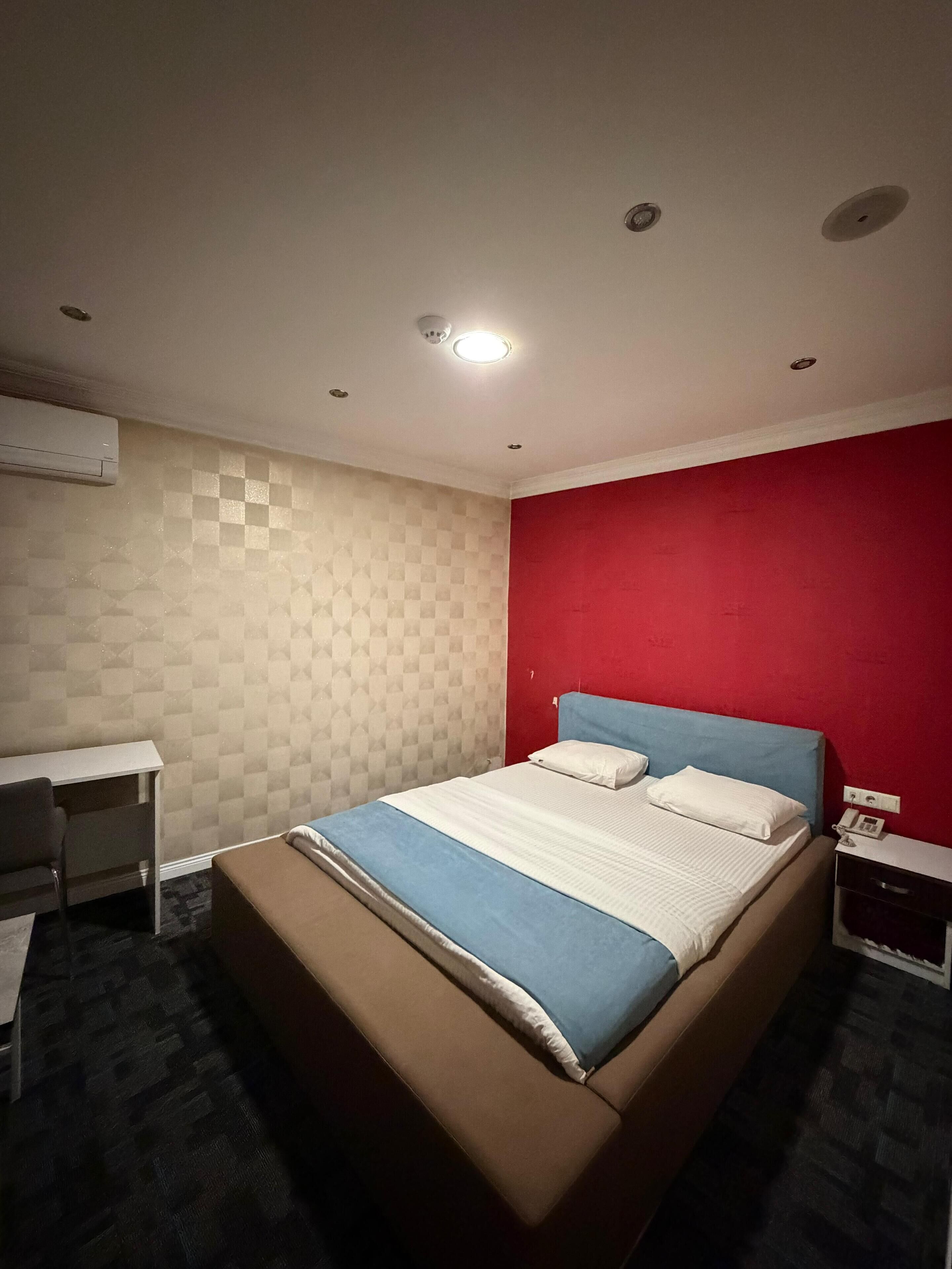 A hotel room with a bed, a desk, and a chair.
