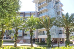 A multi-story hotel with a modern design, featuring balconies and large windows. - Seventh Condo Karon (Karon)