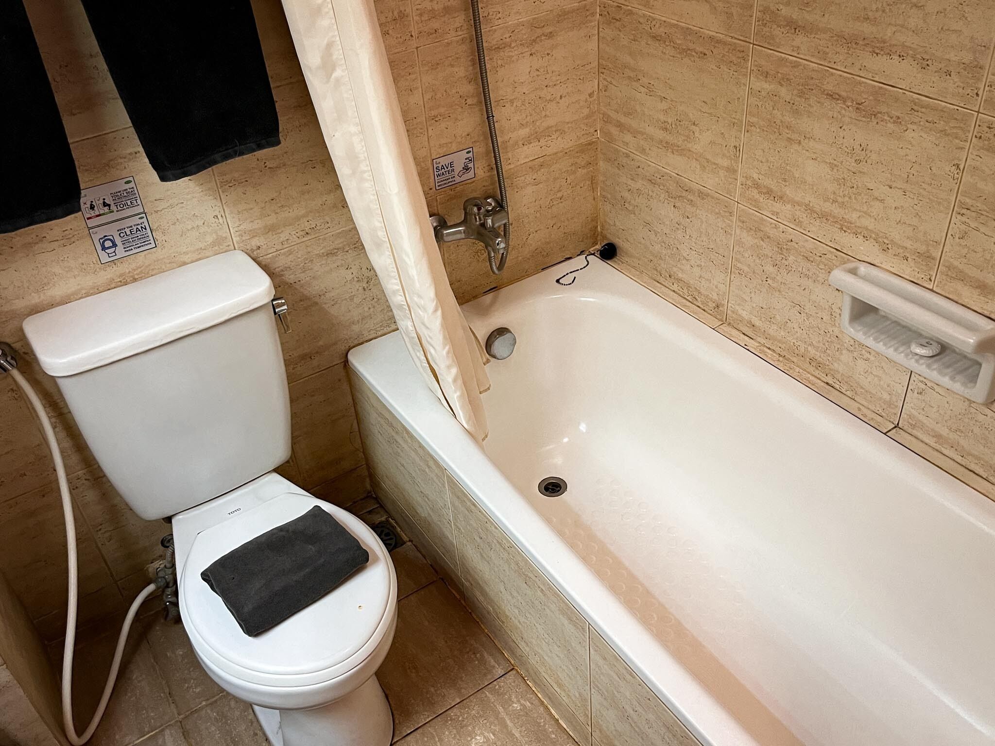 Une salle de bain équipée de toilettes, d’une baignoire et d’une douche.