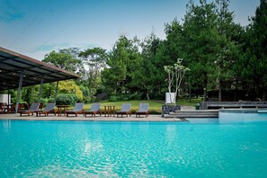 A swimming pool with lounge chairs and a covered area. - Puri Setiabudhi Residence (Bandung)