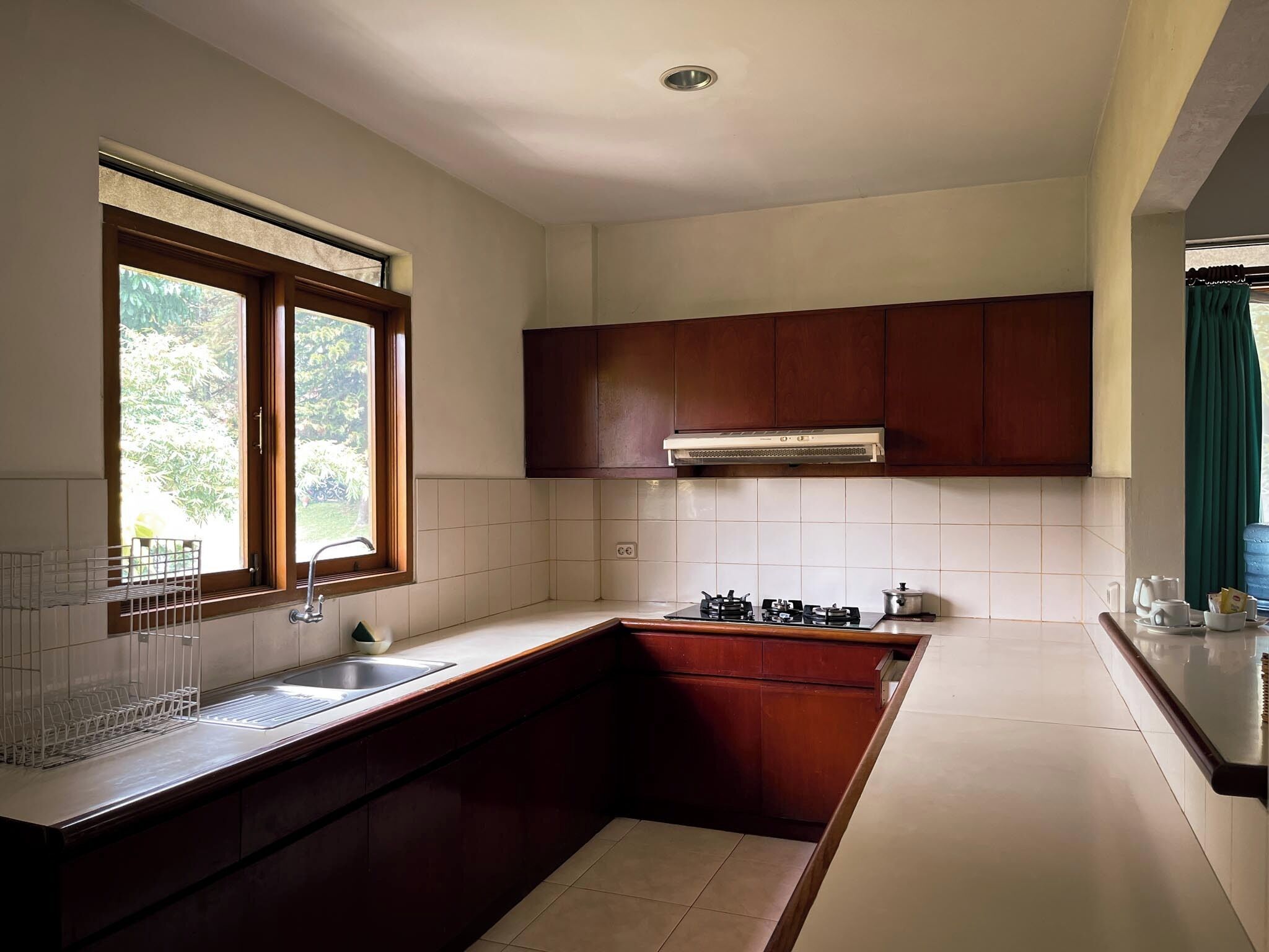 A compact kitchen with a sink, stove, and wooden cabinets.