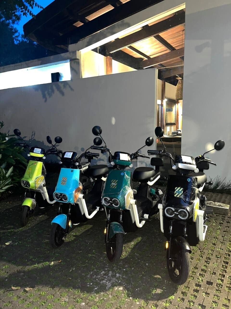 Reihenweise abgestellte Roller vor einem Gebäude mit modernem Design.