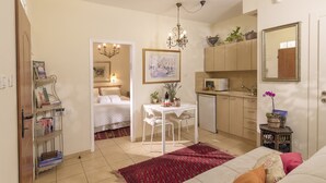 Un espace de vie compact comprenant un lit, une table à manger, un coin cuisine et une petite salle de bain.